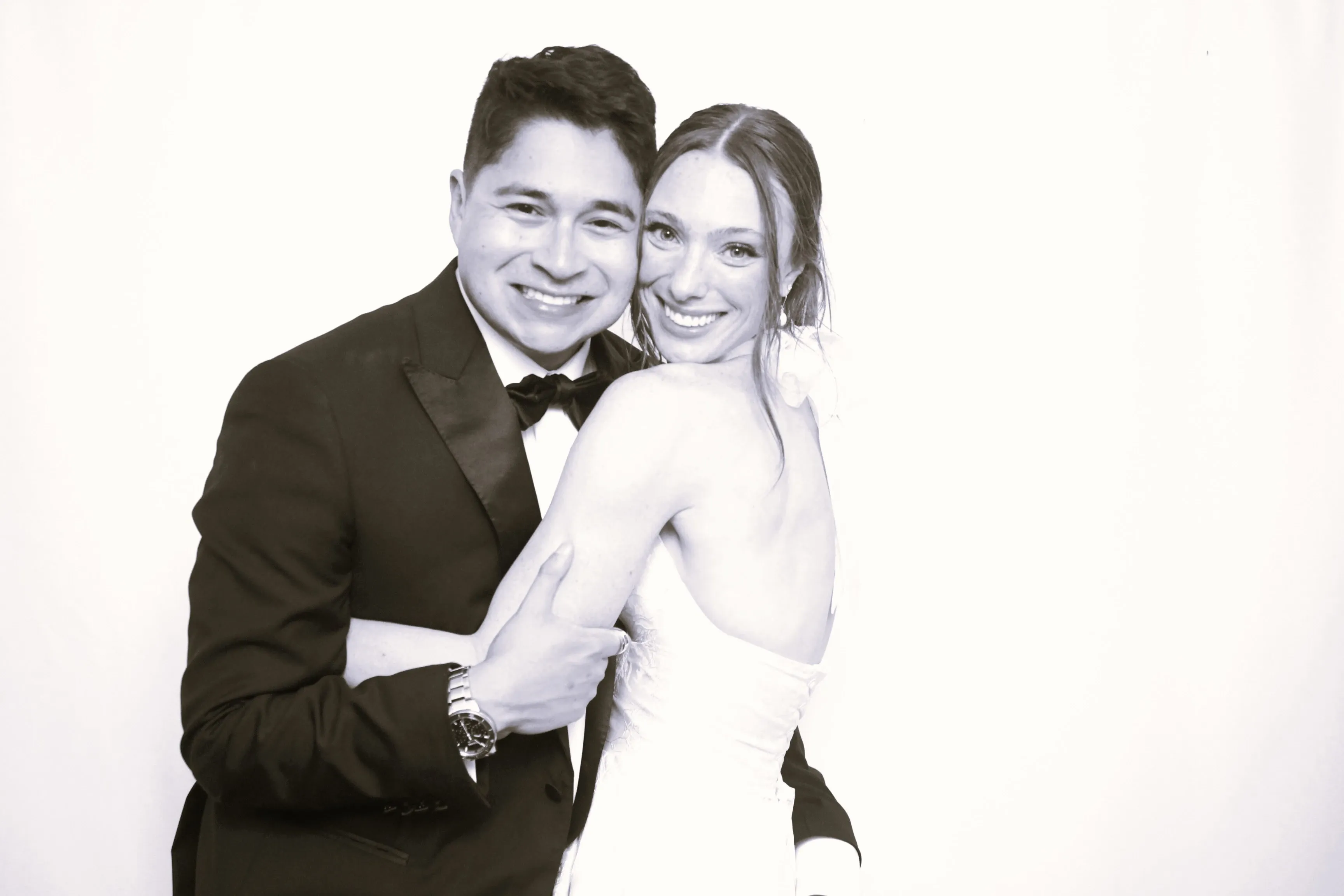 A newlywed couple embracing in a timeless black-and-white wedding portrait
