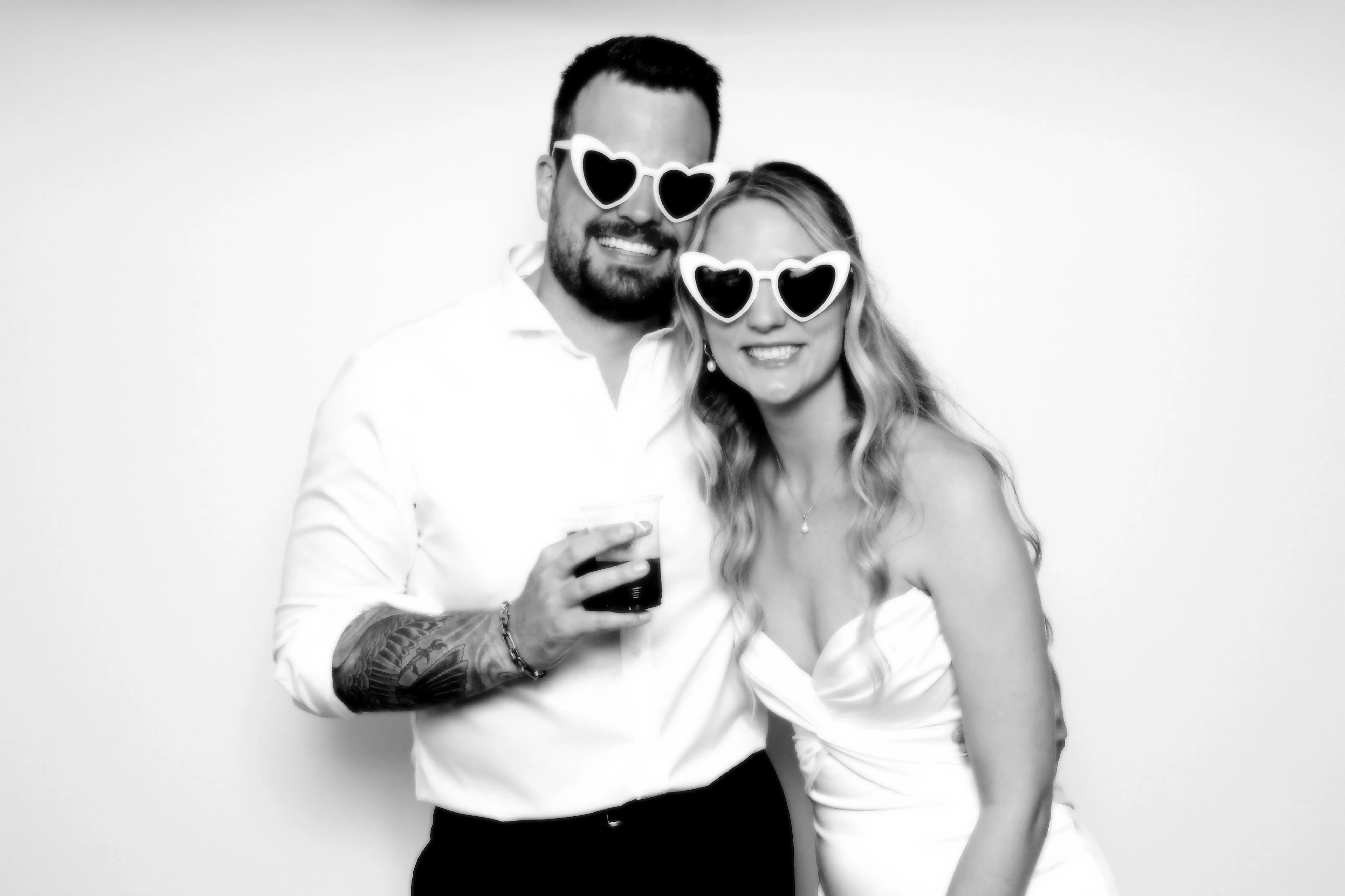 Bride and groom laughing together in heart sunglasses